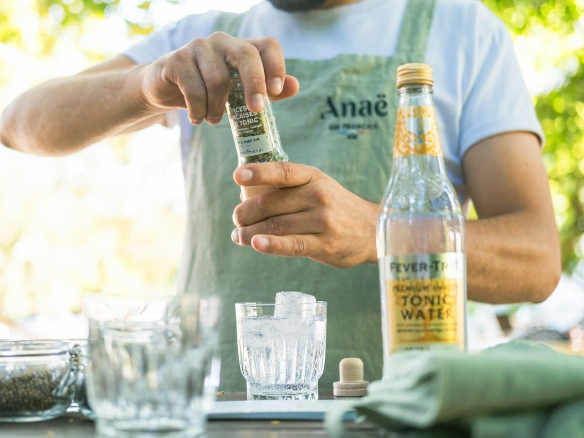 A bartender opening a bottle of tonic water